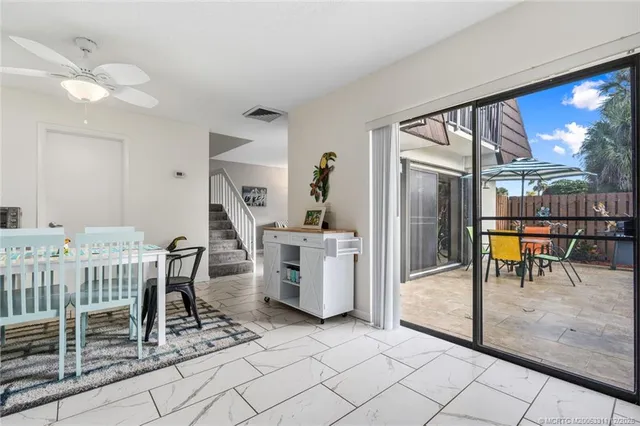a dining room with furniture and a floor to ceiling window