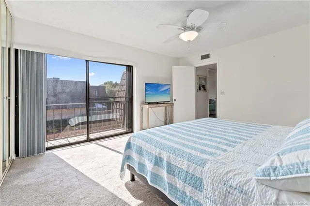 a bedroom with a large bed and a chandelier fan