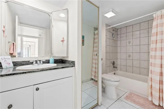 a bathroom with a granite countertop sink mirror toilet and bathtub