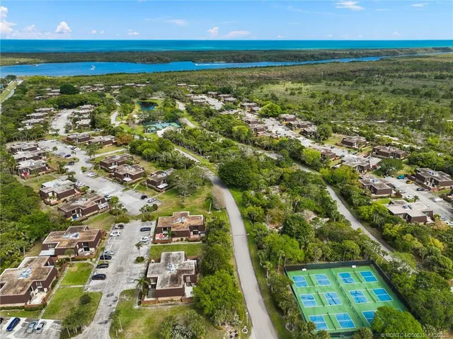 an aerial view of residential houses with outdoor space and trees