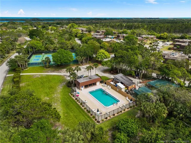 an aerial view of residential houses with outdoor space and swimming pool