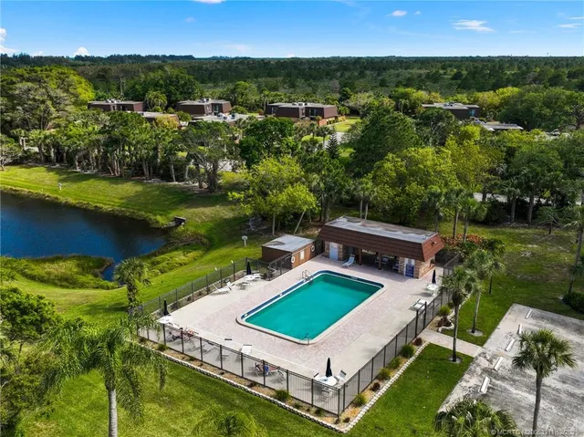 an aerial view of a house with a garden and lake view