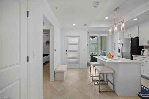 a living room with a sink and a refrigerator