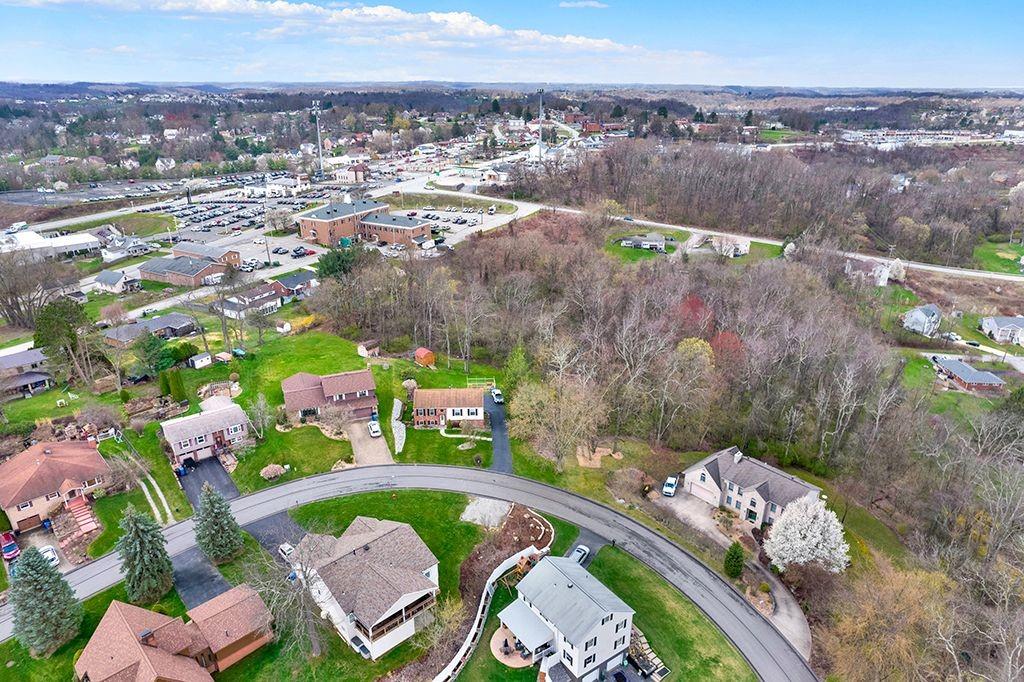 an aerial view of a house a yard and mountain view in back