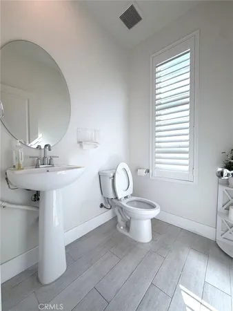 a bathroom with a toilet a sink and mirror