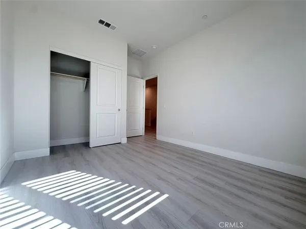 an empty room with wooden floor and closet