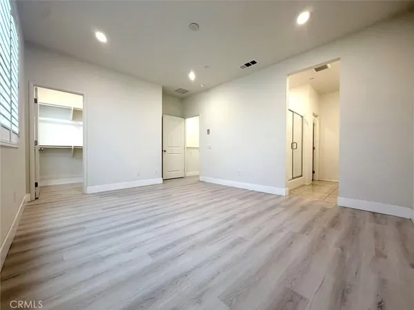 an empty room with wooden floor and a bathroom