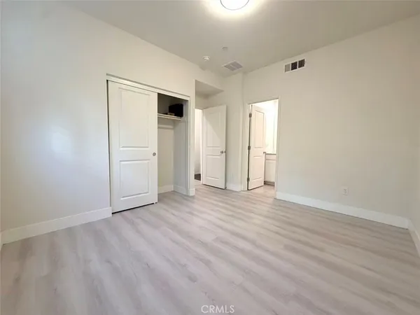 an empty room with wooden floor and closet