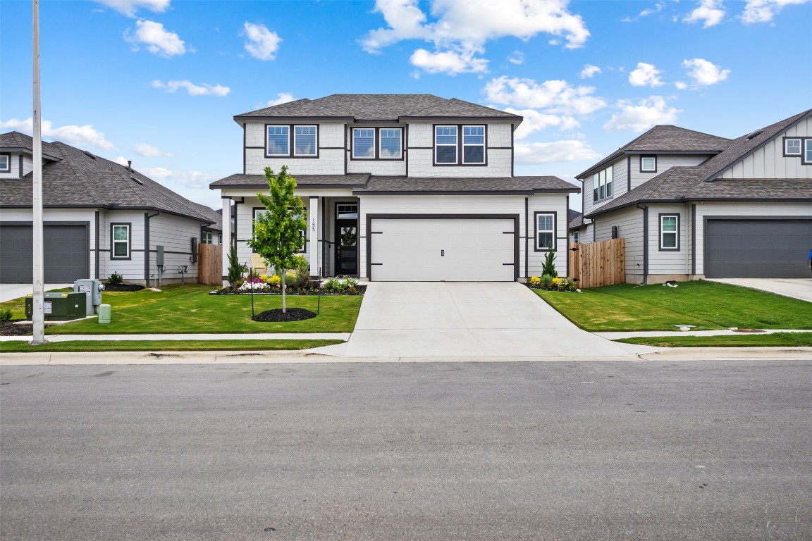 a front view of a house with a yard and potted plants