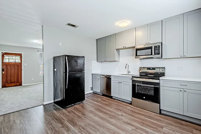 a kitchen with stainless steel appliances granite countertop a refrigerator stove and sink