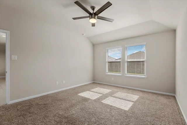 an empty room with a window and a ceiling fan