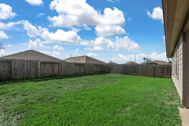 a view of a backyard with wooden fence