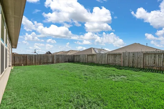 a view of a backyard with wooden fence