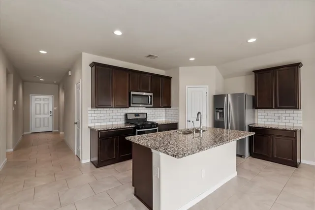 a kitchen with stainless steel appliances granite countertop a sink stove and refrigerator