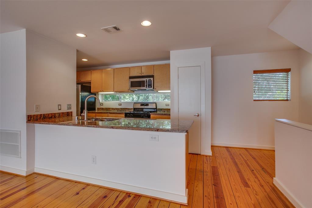 3840 San Jacinto Street Dallas, TX 75204 - Photo 11 of 34 a kitchen with stainless steel appliances a refrigerator and a stove top oven