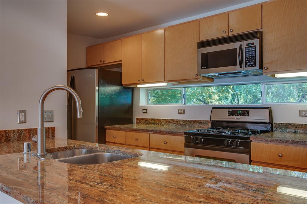 3840 San Jacinto Street Dallas, TX 75204 - Photo 7 of 34 a kitchen with stainless steel appliances kitchen island granite countertop a stove and a sink