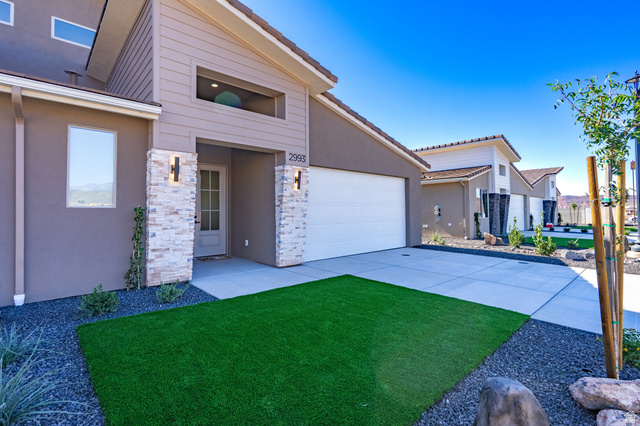 2972 West 570 North Hurricane, UT 84737 - Photo 11 of 104 Mid-century home featuring stucco siding, stone siding, driveway, a front lawn, and an attached garage