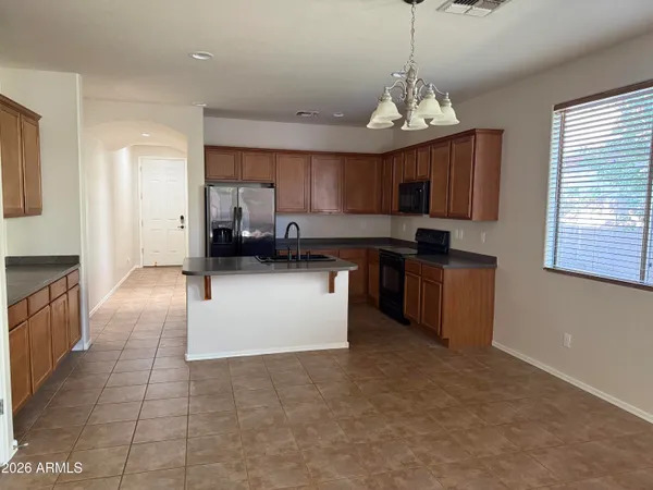 a kitchen with stainless steel appliances granite countertop a stove a sink a microwave and a refrigerator