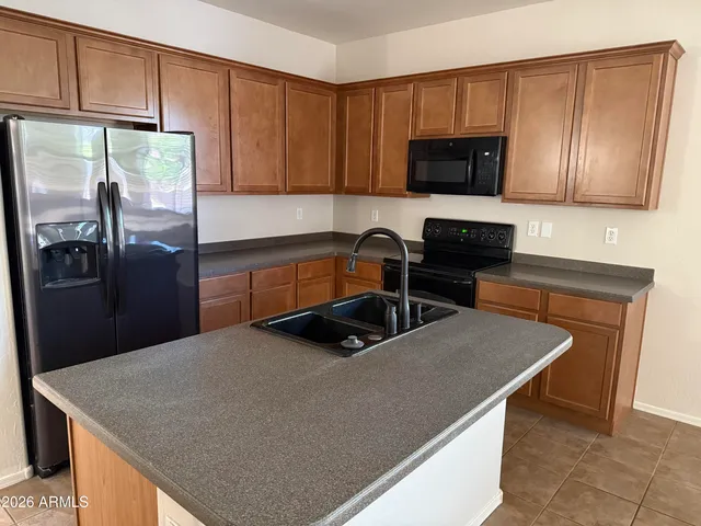 a kitchen with a sink a stove top oven a refrigerator and cabinets