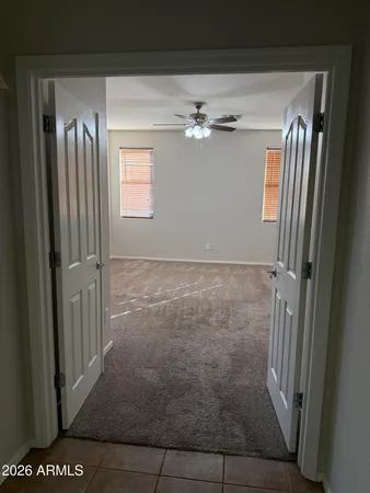 an empty room with a window and a fan