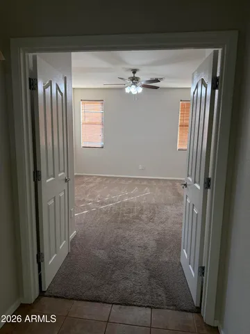 an empty room with a window and a fan