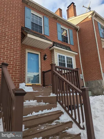 a front view of a house with cars parked