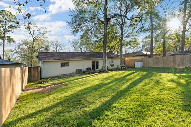 a front view of house with yard and trees in the background