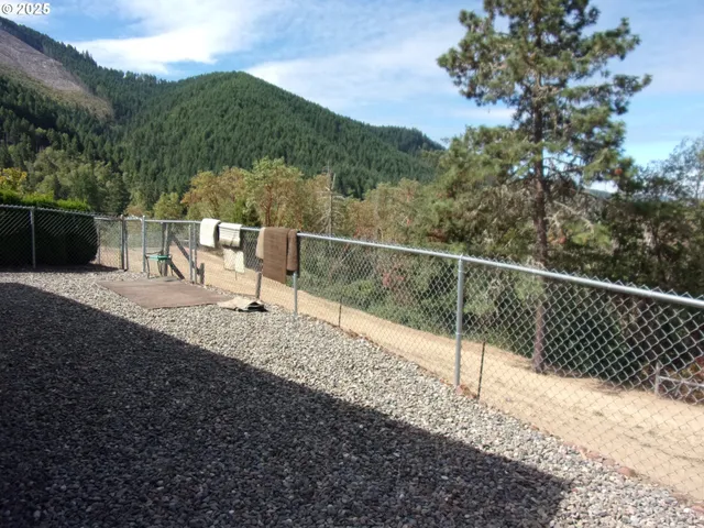 a view of a dry yard with mountains in the background