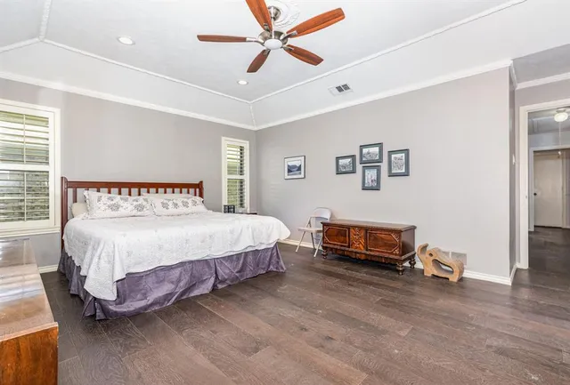 a spacious bedroom with a bed and a ceiling fan