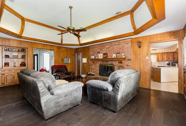 a living room with furniture a fireplace and a ceiling fan