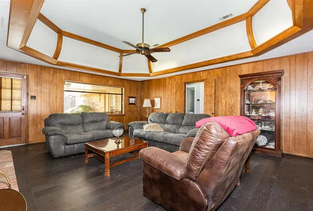 a living room with furniture a ceiling fan and a window