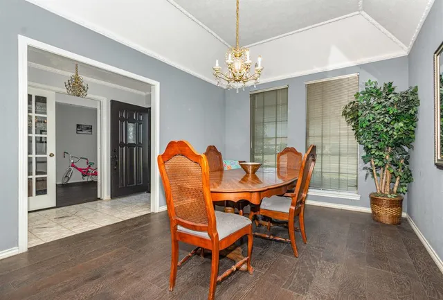 a dining room with furniture potted plants and wooden floor