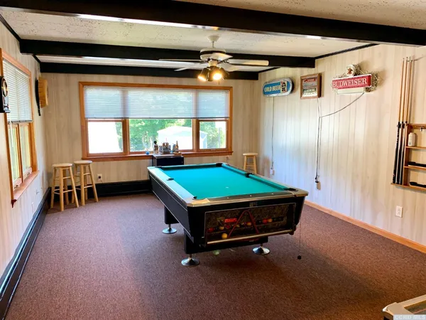 a room with pool table and a large window