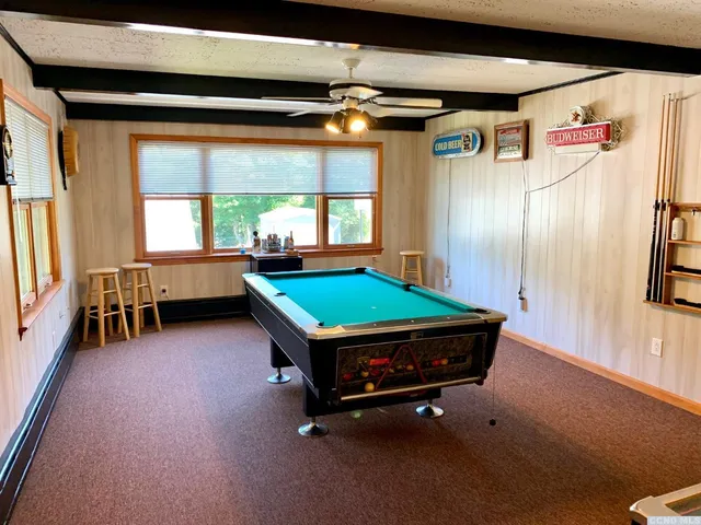 a room with pool table and a large window