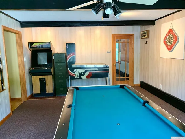 a living room with furniture pool table and flat screen tv