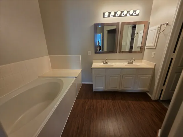 a spacious bathroom with a bathtub shower and a sink