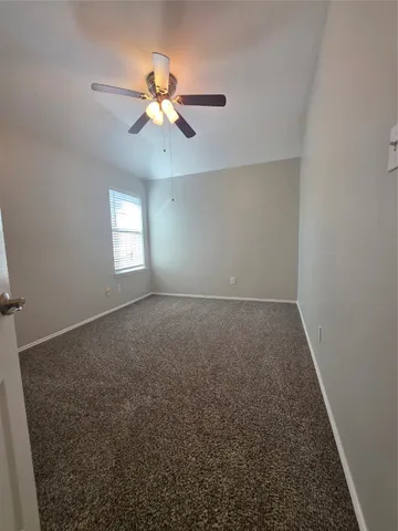 en empty room with windows and chandelier fan