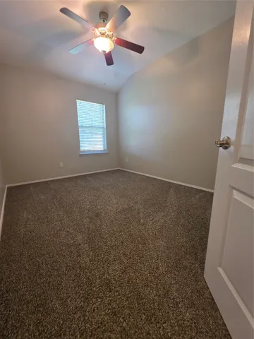 en empty room with windows and fan