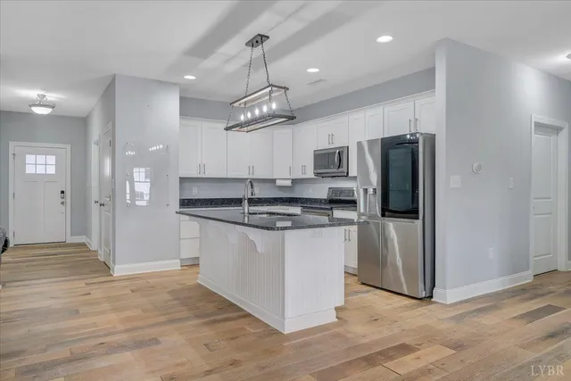 a kitchen with stainless steel appliances granite countertop a sink a stove and cabinets