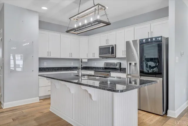 a kitchen with kitchen island granite countertop a sink stainless steel appliances and cabinets