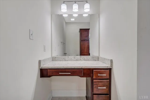 a bathroom with a granite countertop sink a mirror and a shower