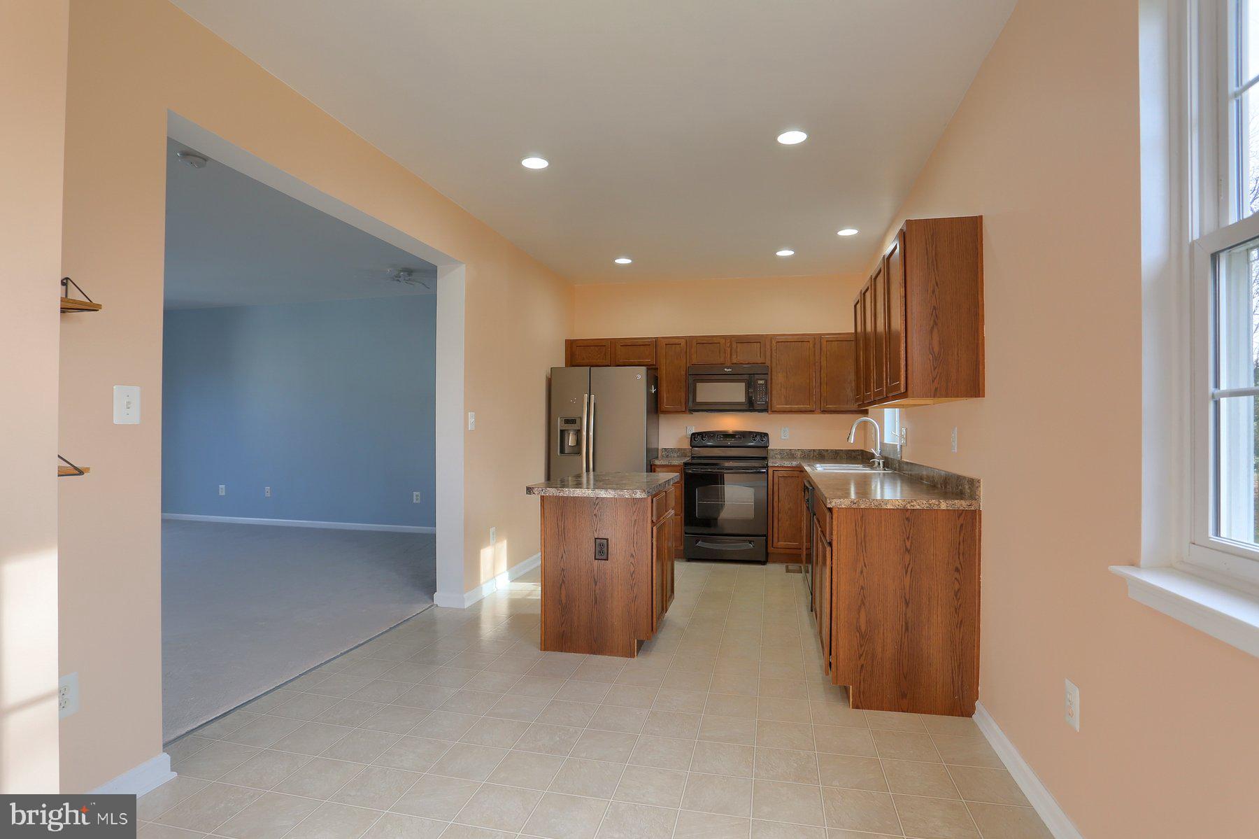 2465 Walnut Bottom Road, Unit 80 York, PA 17408 - Photo 17 of 36 a kitchen with stainless steel appliances kitchen island granite countertop a refrigerator and a sink