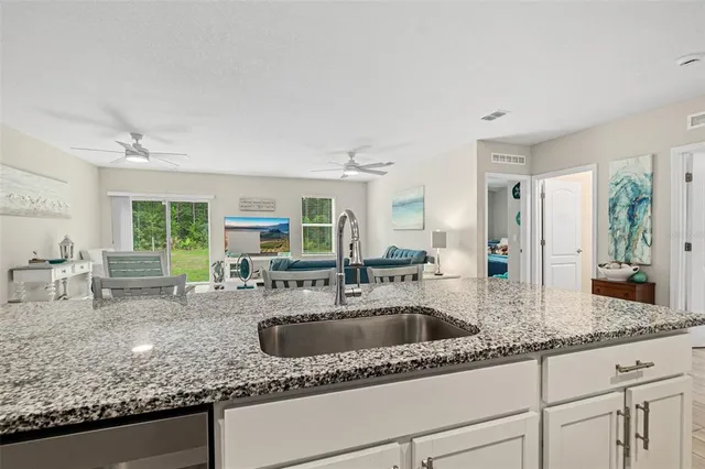 a kitchen with granite countertop a sink and a large window