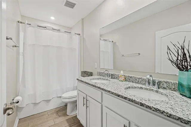 a bathroom with a granite countertop sink toilet and shower