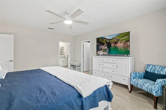 a bedroom with a bed a couch and a flat screen tv