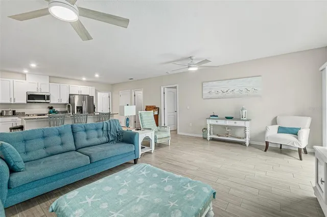 a living room with furniture kitchen view and a potted plant