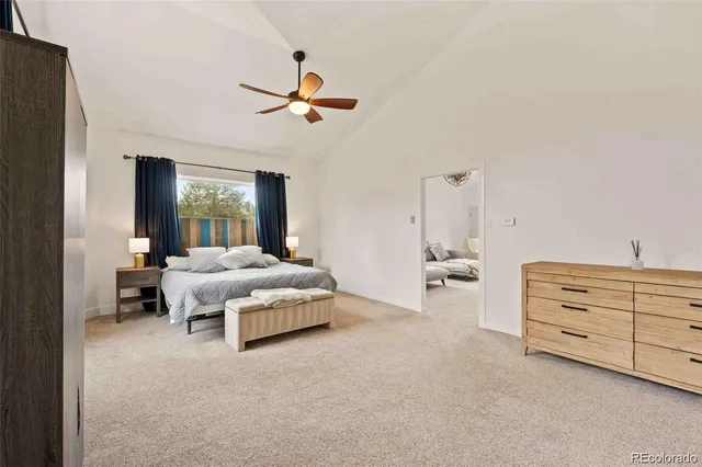 a spacious bedroom with a bed and a chandelier