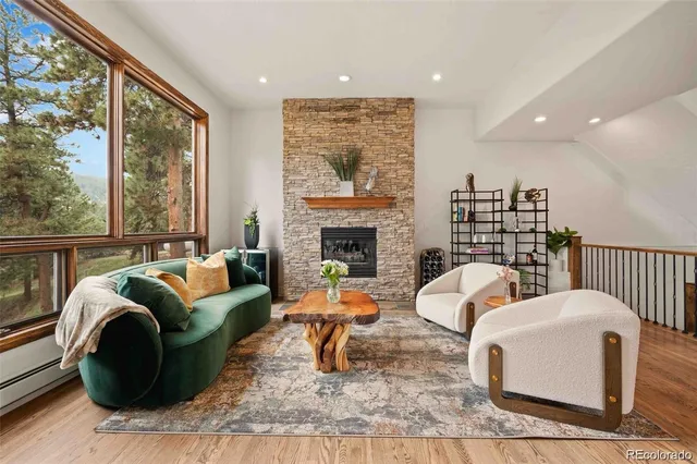 a living room with fireplace furniture and a large window