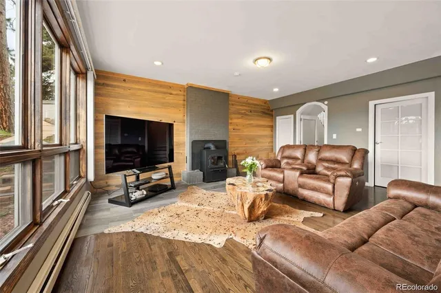 a living room with furniture flat screen tv and a large window