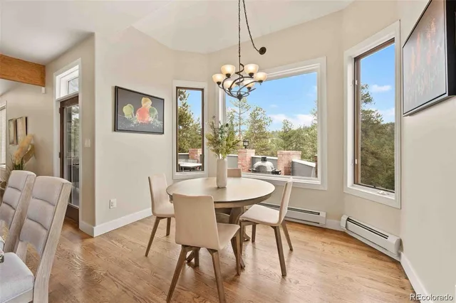 a view of a dining room with furniture a chandelier and wooden floor